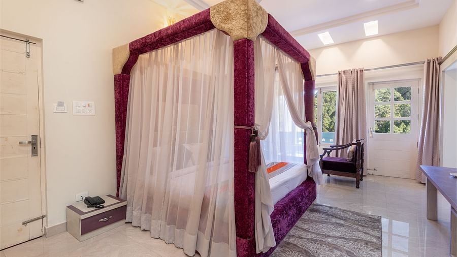 King size bed with a canopy in a beautifully decorated room at DLS Tehri Club Resort.